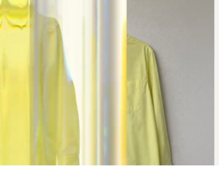 Yellow shirt product image on a pale background